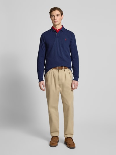 Männermodel trägt Slim Fit Poloshirt aus reiner Baumwolle von Polo Ralph Lauren in Optik: Unifarben, Piqué-Struktur, Ganzkörperansicht von vorne.