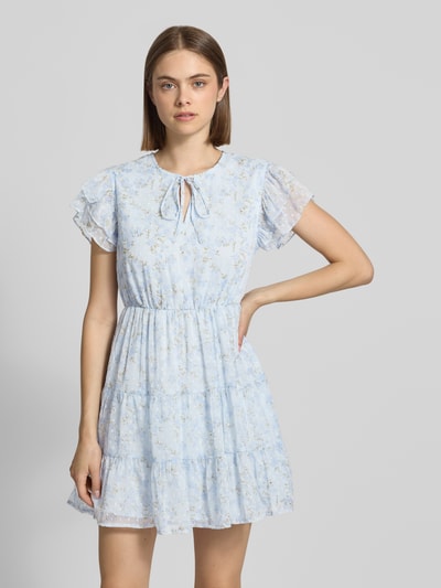 Frauenmodel trägt Tailliertes Freizeitkleid mit Volants Modell 'ELIZA' von Only, florales Allover-Muster in Hellblau, Crinkle-Design, Mini-Länge, Rundhals-Ausschnitt, Ganzkörperansicht von vorne.