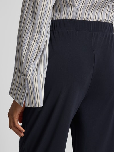Vrouwenmodel draagt Relaxed Fit Stoffhose mit Tunnelzug van MM by Max Mara, donkerblauw, met steekzakken en riemlussen, detailopname rug.