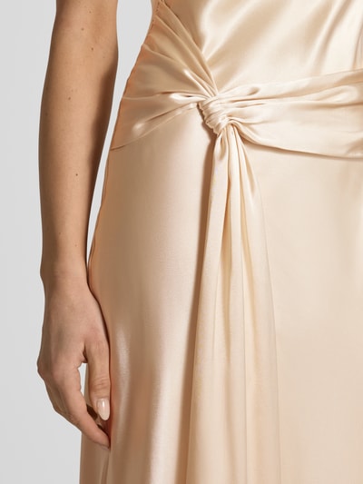 Vrouwenmodel draagt Abby avondjurk van Forever New, satijn in beige, nauwsluitend maxijurk, detailopname heup en taille.