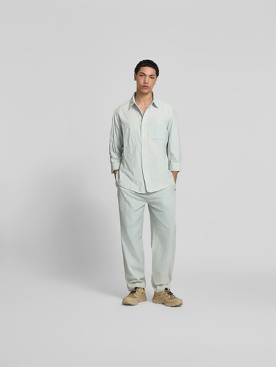 Männermodel trägt Relaxed Fit Sweatpants in Denim-Optik von Kenzo in Hellblau, reine Baumwolle, elastischer Bund, Ganzkörperansicht von vorne.