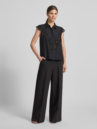 Modelka nosi Regular Fit Blusentop aus Modal-Mix Modell 'COLE' od Copenhagen Muse, czarny, strukturalny materiał, kołnierzyk koszulowy, ukryta listwa guzikowa, długość tyłu 59 cm w rozmiarze S, Ganzkörperansicht von vorne.