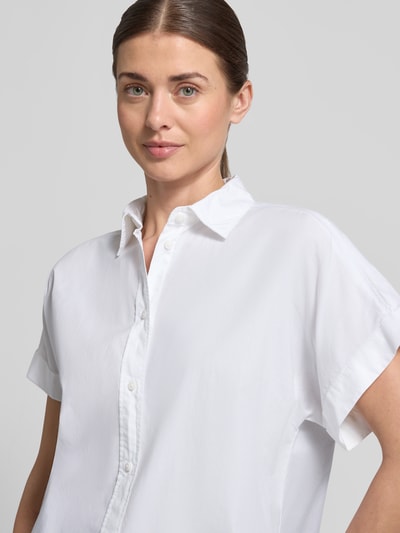 Frauenmodel trägt Regular Fit Hemdbluse mit Hemdblusenkragen Modell 'Isabel' von ECOALF aus Reine Baumwolle, Kurzärmelig, Durchgängige Knopfleiste, Nahaufnahme Oberkörper.