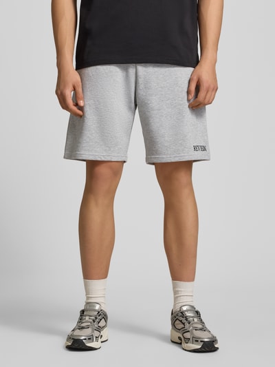 Männermodel trägt Regular Fit Shorts mit Label-Stitching von REVIEW in Hellgrau, Baumwoll-Mix, elastischer Bund, Nahaufnahme Oberkörper.