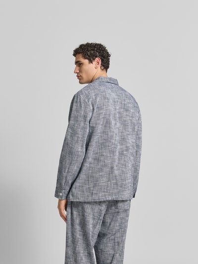 Männermodel trägt Relaxed Fit Hemdjacke aus Baumwolle von Officine Générale mit Reverskragen und Eingrifftaschen, Rückansicht.