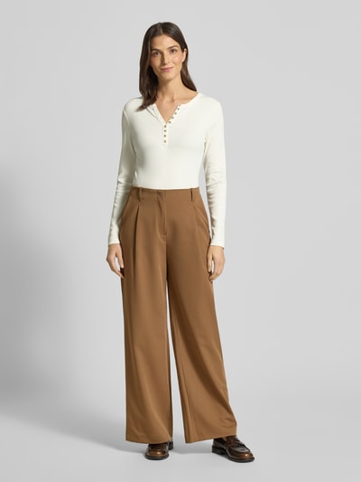 Frauenmodel trägt Slim Fit Longsleeve aus Baumwoll-Mix mit Henley-Ausschnitt von Christian Berg Woman in Weiß, glatte Textur, kombiniert mit brauner, weiter Hose, Rückenlänge bei Größe S 58 cm, Ganzkörperansicht von vorne.