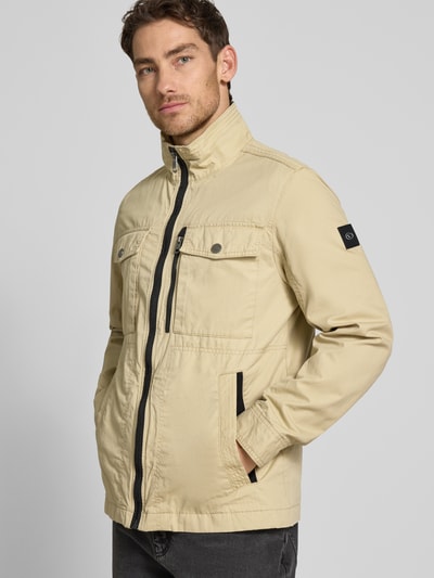 Mężczyzna model nosi Regular Fit Jacke aus reiner Baumwolle von Tom Tailor, dwukolorowy, zamek błyskawiczny, wpuszczane kieszenie, nakładane brustasza, kieszeń wewnętrzna, materiał bawełna, krój regular fit, Ganzkörperansicht von vorne.