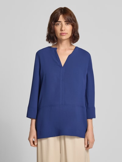 Frauenmodel trägt Regular Fit Bluse mit V-Ausschnitt und 3/4-Arm von Marc Cain in Blau, Damen Bluse, glatte Textur, Ganzkörperansicht von vorne.