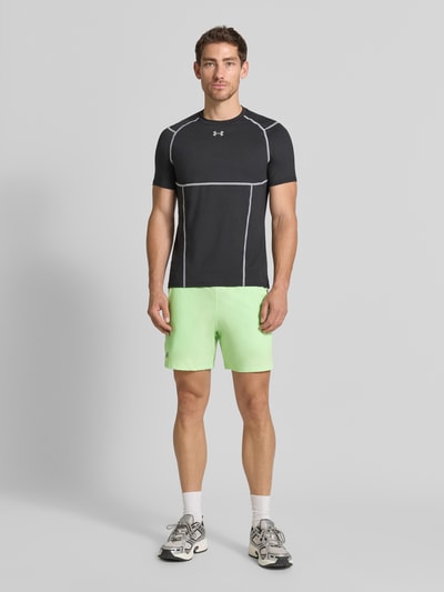 Männermodel trägt Shorts mit elastischem Bund und Logo von Under Armour in lichtgroen, regular fit, steekzakken, ganzkörperansicht von vorne.