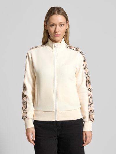 Frauenmodel trägt Sweatjacke mit Stehkragen und Eingrifftaschen Modell 'BRITNEY' von Guess Activewear, Regular Fit, beige, Ganzkörperansicht von vorne.