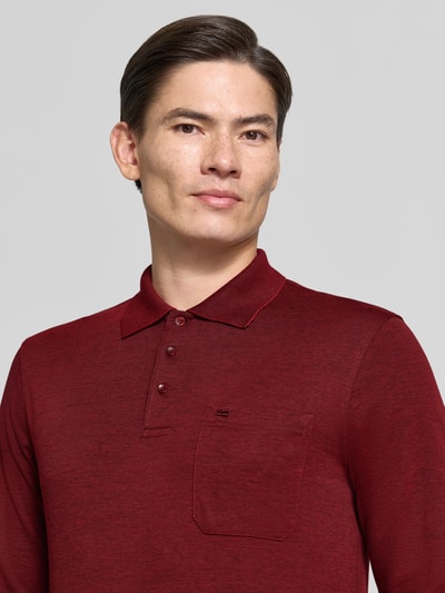Männermodel trägt Regular Fit Poloshirt mit Baumwoll-Anteil von Christian Berg Men in Dunkelrot, Material-Mix, Nahaufnahme Oberkörper.