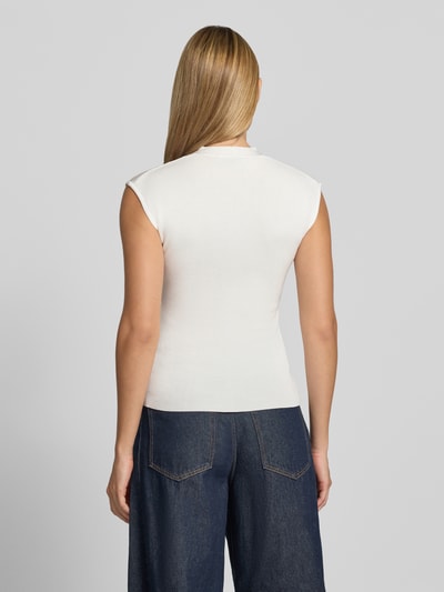 Frauenmodel trägt Stricktop mit V-Ausschnitt Modell 'CANELONS' von MANGO, weiß, feine Textur, taillierter Schnitt, Ganzkörperansicht Rückansicht. Viskose-Mix, Rückenlänge Größe S 56 cm.