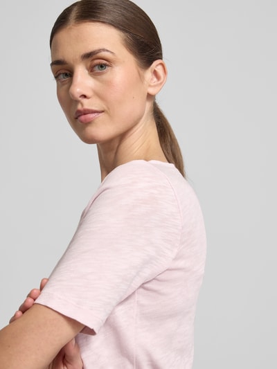 Frauenmodel trägt Slim Fit T-Shirt aus reiner Baumwolle von Marc O'Polo, unifarben Melange in Hellrosa, Logo-Print, Nahaufnahme Oberkörper.