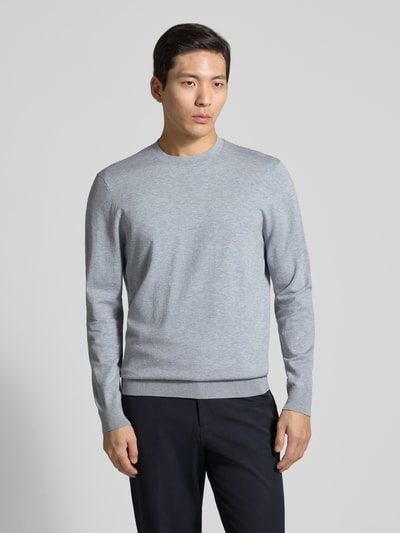 Męski model nosi Regular Fit Pullover aus Lyocell-Mix mit Seiden-Anteil od Profuomo, jasnoszary melanż, okrągły dekolt, krój regular fit, dzianinowa faktura, elastyczne wykończenia, widok całej sylwetki z przodu.