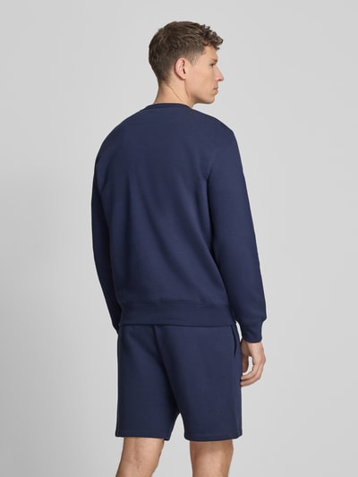 Männermodel trägt Sweatshirt mit Logo und Rundhalsausschnitt von GAP aus Baumwoll-Mix in Dunkelblau, Regular-Fit, Rückenansicht.