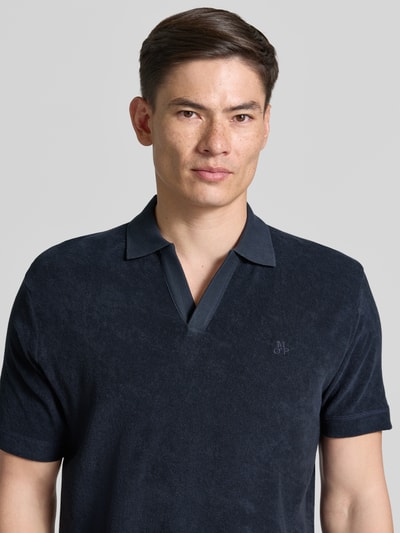 Männermodel trägt Regular Fit Poloshirt aus reinem Baumwoll-Frottee von Marc O'Polo in Dunkelblau, strukturierte Textur, Nahaufnahme Oberkörper. Herren Poloshirt