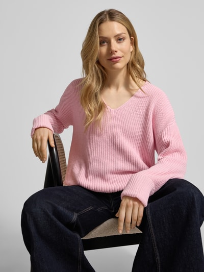 Kobiece modelka ma na sobie Oversized Strickpullover aus Baumwoll-Mix od s.Oliver RED LABEL, różowy, splot ściągaczowy, dekolt V, rękaw 3/4, widok całej sylwetki z przodu.