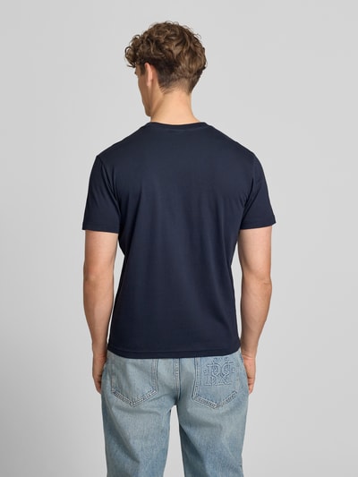 Männermodel trägt T-Shirt mit Label-Stitching mit Rundhalsausschnitt von CHAMPION in Dunkelblau, reine Baumwolle, Regular Fit, Rückansicht, Ganzkörperansicht.
