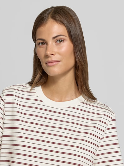 Frauenmodel trägt Boxy Fit T-Shirt aus reiner Baumwolle Modell 'ESSENTIAL' von Selected, weiß mit roten und blauen Streifen, Damen T-Shirt, Nahaufnahme Oberkörper.