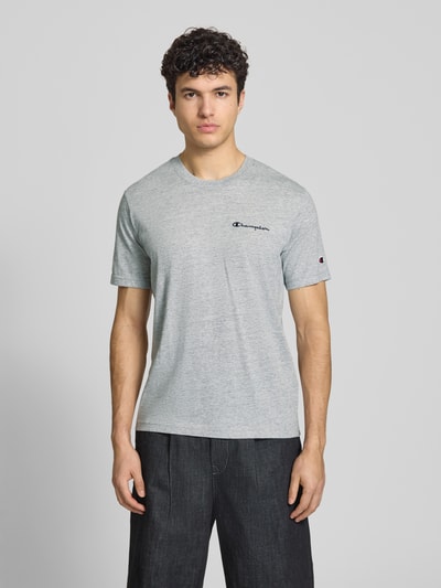 Męski t-shirt z mieszanki bawełny w nowoczesnym kroju, model 'ICONS CONTRAST' od CHAMPION, wyhaftowane logo, okrągły dekolt, długość tyłu w rozmiarze M: 70 cm, jasnoszara kolorystyka, widoczne tekstury materiału, Ganzkörperansicht von vorne.
