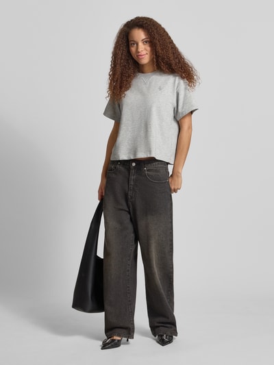 Frauenmodel trägt kurzärmeliges Sweatshirt mit Stickerei von REVIEW in Grau aus Baumwoll-Mix mit Viskose-Anteil, Relaxed-Fit, 1/2-Arm, Rückenlänge bei Größe S 53 cm, Ganzkörperansicht von vorne.