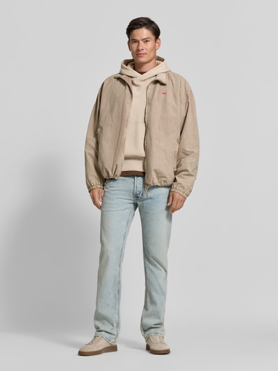 Mannenmodel draagt Straight Fit Jeans uit katoenmix van Diesel, 5-pocketmodel, logodetail, knoop- en ritssluiting, lichtblauw, full body vooraanzicht. Heren jeans, binnenbeenlengte maat 32/32: 81 cm, bandwijdte maat 32/32: 41 cm.
