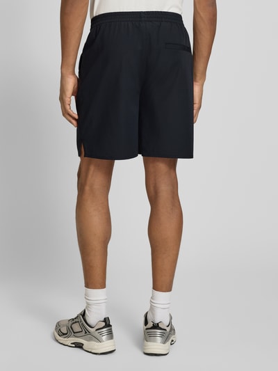 Männermodel trägt Shorts mit elastischem Bund Modell 'Raphael' von Les Deux, Material-Mix, dunkel, Ganzkörperansicht Rückansicht.