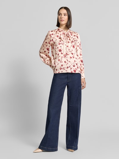 Vrouwenmodel draagt Regular Fit Schluppenbluse im Allover-Look van Christian Berg Woman Selection, lichtroze met rode bloemen, gladde stof, dames blouse, ruglengte 62 cm, mouwlengte 64 cm, full body vooraanzicht.