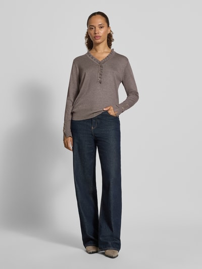 Vrouwenmodel draagt Regular fit pullover met woll-alpaca-aandeel Model 'Katie' van FREE/QUENT, Materiaalmix, tricotlook, v-hals, met ruches, knoopsluiting, bruine tinten, lange mouwen, maat S ruglengte 60 cm, mouwlengte 60 cm, jeans, Ganzkörperansicht van voren.