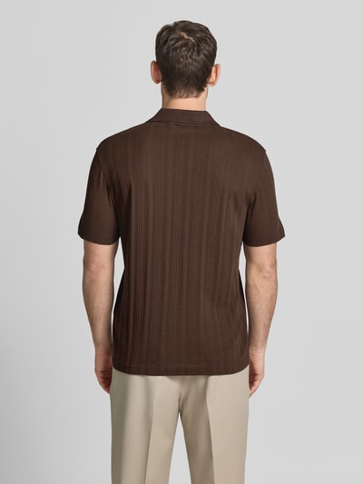 Männermodel trägt Regular Fit Poloshirt aus Baumwoll-Mix Modell 'TRAVIS' von SELECTED HOMME in Braun, Struktur, Ganzkörperansicht Rückansicht.