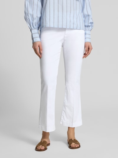 Kobiece modelka nosi białe bootcut jeansy w 5 kieszeni, model 'Mary' od Brax z mieszanki bawełny i lyocellu z dodatkiem streczu, fason z rozszerzanymi nogawkami, detal z logo, szerokość w rozmiarze 36: 39 cm, długość wewnętrzna nogawki 67 cm, widok z przodu, ujęcie całej sylwetki.