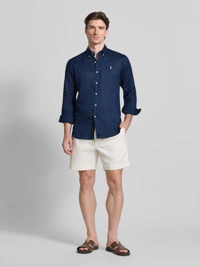 Männermodel trägt Regular Fit Freizeithemd aus reinem Leinen von Polo Ralph Lauren in Dunkelblau, unifarben, Ganzkörperansicht von vorne.