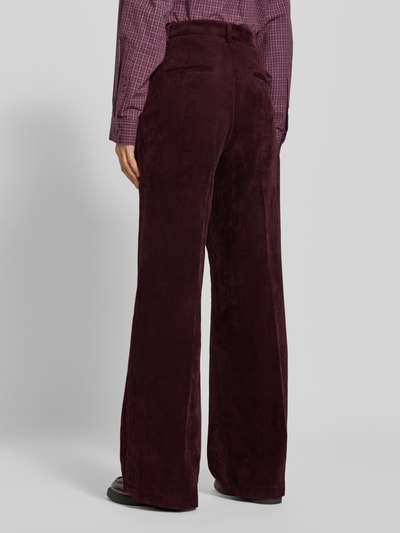 Frauenmodel trägt Regular Fit Cordhose mit angedeuteten Taschen Modell 'AMELIE' von CAMBIO in Dunkelrot, Ganzkörperansicht Rückansicht. Damen Cordhose von CAMBIO.