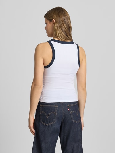 Vrouwenmodel draagt Tanktop in Ripp-Optik mit Label-Stitching van Guess Jeans, katoenmix met modal, slim fit, riblook, ruglengte maat S 50 cm, Ganzkörperansicht Rückansicht.