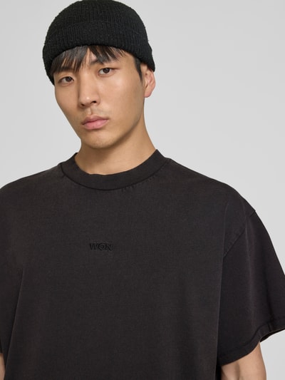 Männermodel trägt Relaxed Fit T-Shirt mit Logo-Stitching von WON HUNDRED aus reiner Baumwolle, Rundhalsausschnitt, kurzärmelig, Nahaufnahme Oberkörper.