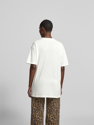 Frauenmodel trägt Oversized T-Shirt aus reiner Baumwolle von Anine Bing in Weiß mit Rundhalsausschnitt, Halbarm und Label-Print. Ganzkörperansicht Rückansicht.