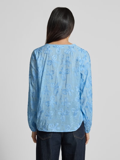 Frauenmodel trägt Bluse aus Viskose-Mix mit Knopfleiste Modell 'Randy' von FREE/QUENT in Hellblau, florale Struktur, Rückansicht, Damenmode, Straight Fit, Serafino-Kragen, elastische Ärmelabschlüsse