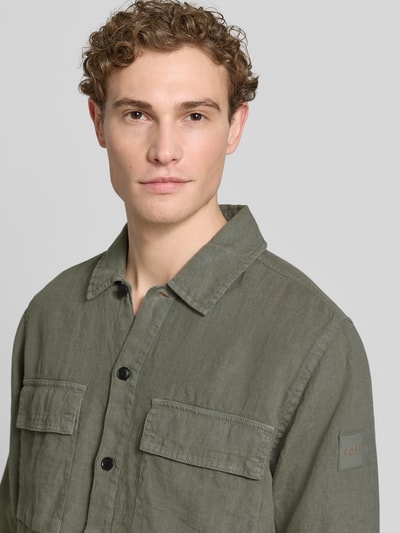 Männermodel draagt Relaxed Fit vrijetijdsoverhemd uit puur linnen model 'LOCKY' van BOSS Orange, look: effen kleuren, kentkraag, doorlopende knoopsluiting, labelpatch, borstzakken, gevlamd garen materiaalverwerking, langemouw, materiaal: linnen, Nahaufnahme Oberkörper.