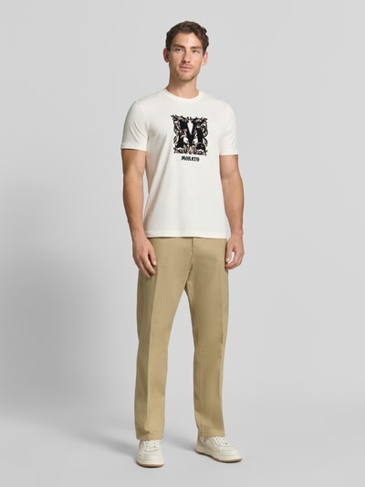 Männermodel trägt Relaxed Fit Stoffhose aus reiner Baumwolle Modell 'BEN' von Antony Morato in Beige mit Bundfalten, Ganzkörperansicht von vorne. Herren Stoffhose, 5-Pocket-Design, Knopf- und Reißverschluss, Kontext: Bundweite 50 cm, Innenbeinlänge 80 cm bei Größe 50.