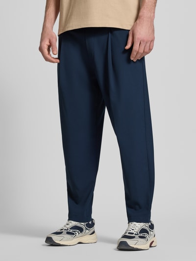 Männermodel trägt Relaxed Fit Bundfaltenhose mit Viskose-Anteil Modell 'VIGGO CROPPED' von Marc O'Polo Denim, Optik: Unifarben, Nahaufnahme Unterkörper.