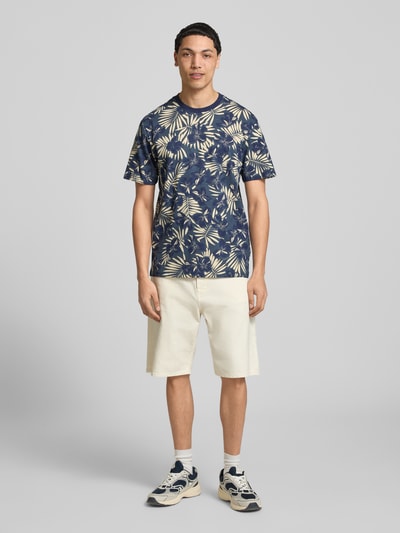 Männermodel trägt Regular Fit T-Shirt aus reiner Baumwolle Modell 'PERRY' von Only & Sons mit Optik:Allover-Muster, Ganzkörperansicht von vorne.