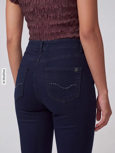 Frauenmodel trägt Straight Fit Jeans aus Baumwoll-Mix Modell 'LIV' von TONI in dunklem Blau, grober Stoff, Damen Straight Fit Jeans von TONI, Nahaufnahme Rückansicht, KI-modifiziertes Bild.