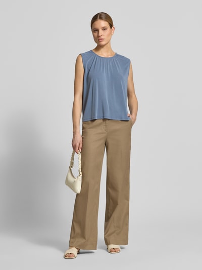 Frauenmodel trägt Loose Fit Blusentop aus Modal-Mix Modell 'FILLI' von Vero Moda, unifarben, ohne Ärmel, Ganzkörperansicht von vorne.