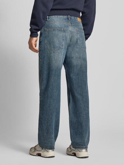 Männermodel trägt Jeans mit 5-Pocket-Design von REVIEW in Blau mit geradem Schnitt, Struktur leicht verwaschen, Ganzkörperansicht Rückansicht