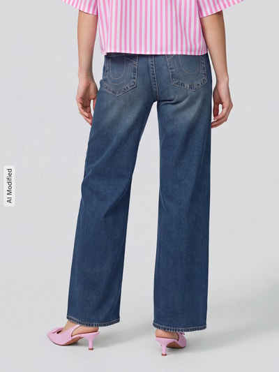Mężczyzna nosi jeansy o kroju baggy z mieszanki modalu i bawełny, model 'Bobbi' od TRUE RELIGION, damskie, widok całej sylwetki z tyłu, obraz zmodyfikowany przez AI