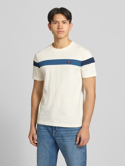 Männermodel trägt Regular Fit T-Shirt mit Logo-Detail Modell 'Caserio' von Ellesse in Creme mit blauem Streifen, reine Baumwolle, Nahaufnahme Oberkörper.