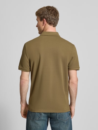 Männermodel trägt Straight Fit Poloshirt mit Label-Stitching von Calvin Klein Jeans in Khaki, reine Baumwolle, gerippte Ärmelabschlüsse, Ganzkörperansicht Rückansicht.