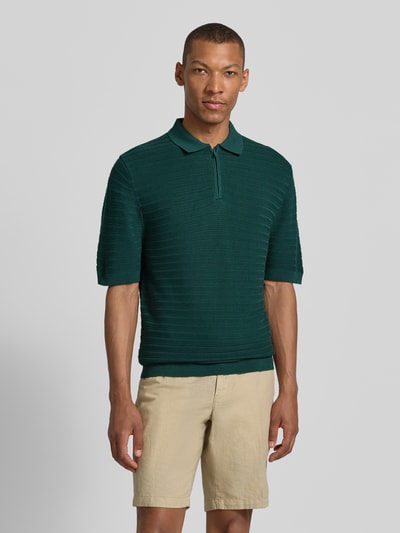 Männermodel trägt Regular Fit Poloshirt mit kurzem Reißverschluss von MCNEAL im Baumwoll-Mix mit Viskose-Anteil, Strukturmuster, Polokragen, grün, Ganzkörperansicht von vorne.