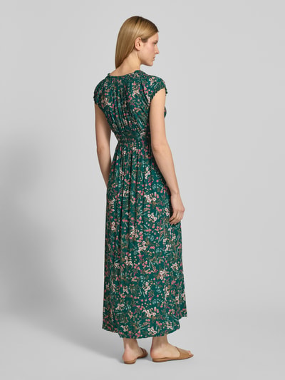 Kobiece model prezentuje Regular Fit Maxikleid aus reiner Viskose mit V-Ausschnitt von Apricot, zielony nadruk na całej powierzchni, krótkie rękawy, obszycie falbanami, dopasowany krój, efekt plisowania, długość tyłu w rozmiarze S: 129 cm, szerokość w rozmiarze S: 46 cm, widok całej sylwetki z tyłu.