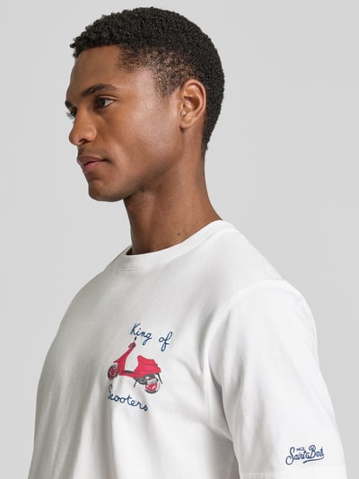 Męski model nosi t-shirt z haftami model 'PORTOFINO' od MC2 Saint Barth, bawełna, krój regular fit, okrągły dekolt, długość tyłu 68 cm w rozmiarze M, zbliżenie na górną część ciała.